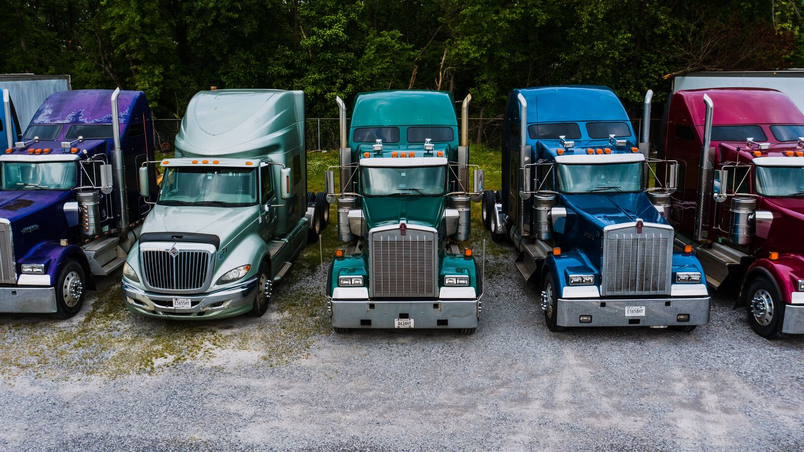 A row of semi trucks parked at a truck stop, representing the range of the Truckers Dating community across the USA